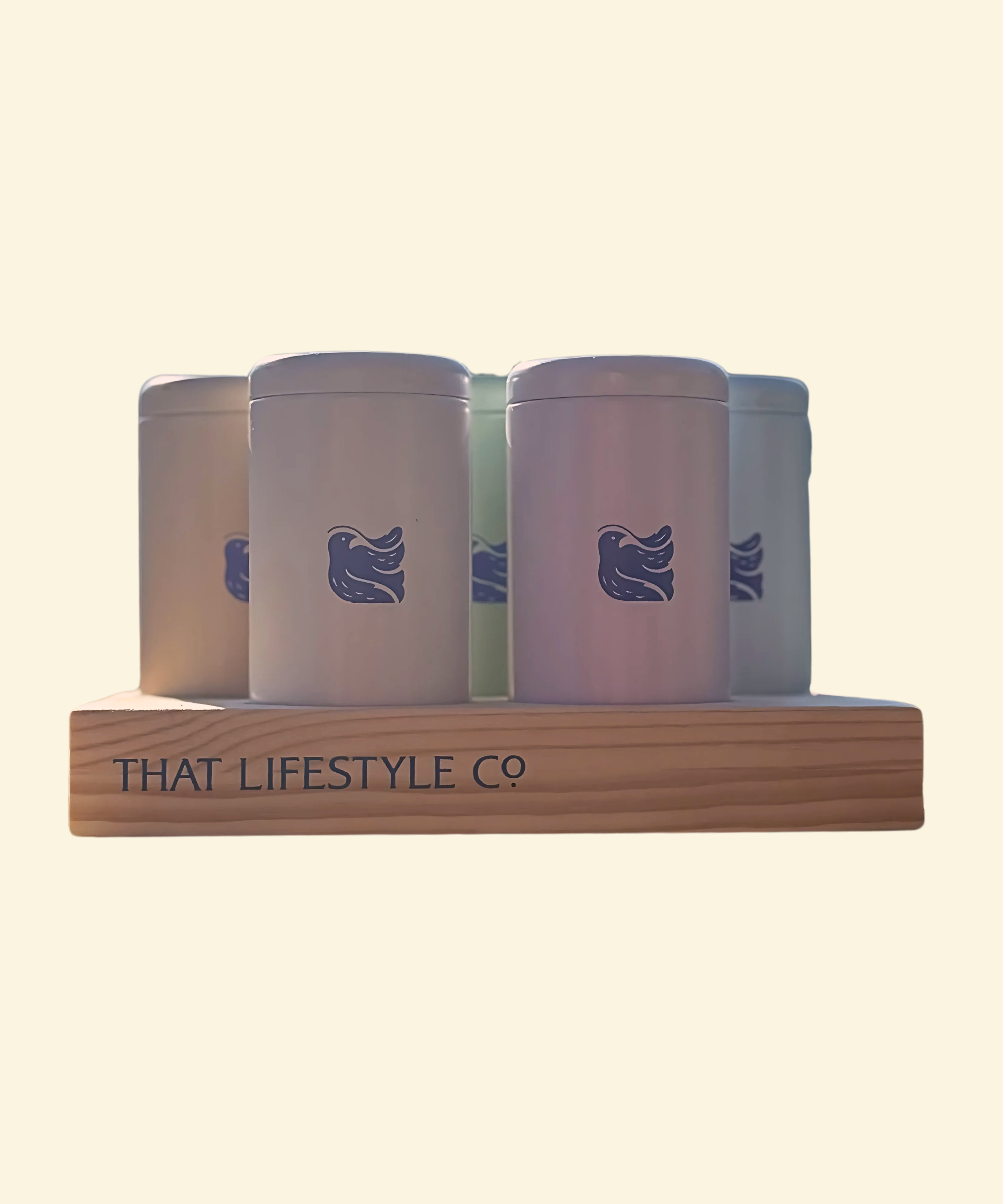 Five elegant tea tins from That Lifestyle Co., neatly arranged on a handcrafted wooden tray with a natural wood finish and the brand logo engraved