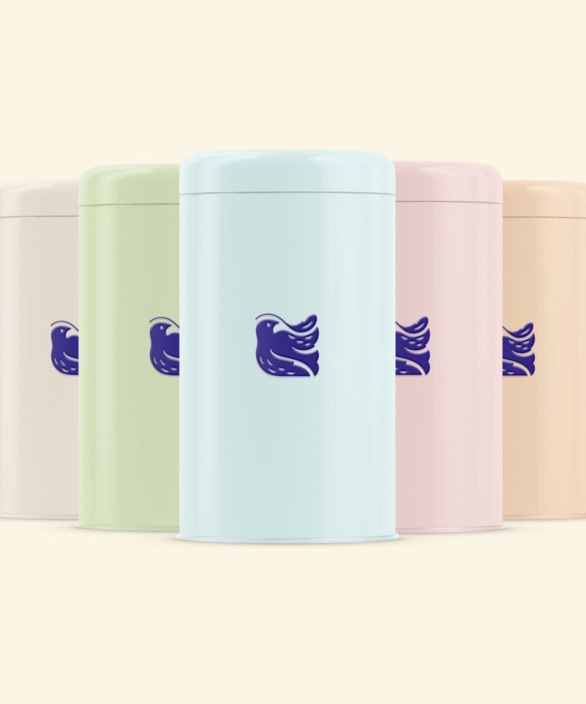 Group of five pastel-coloured reusable tea tins featuring the signature bower bird motif, part of the Organic Swiss Herbal Tea Collection